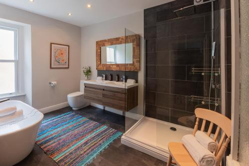 a bathroom with a tub and a shower and a sink at The Clarence in Bishop Auckland