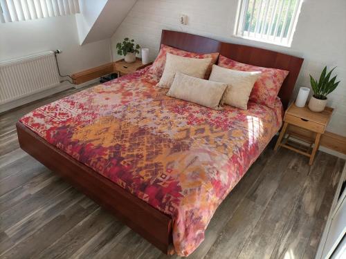 a bedroom with a bed with a red comforter at Bargerveenhuis in Weiteveen