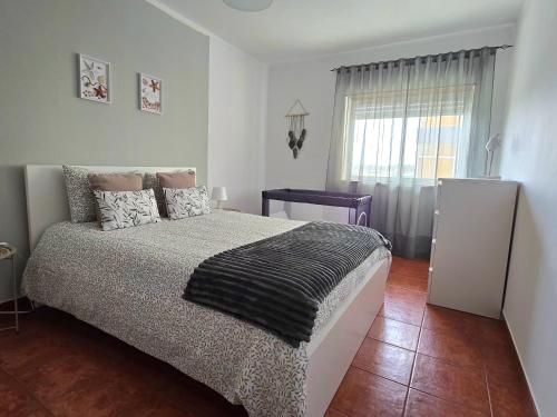 a bedroom with a large bed and a window at JB House in Peniche