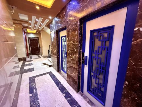 a hallway with blue doors in a building at Winter House in Luxor