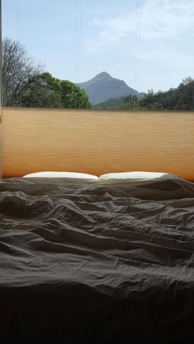 a bed in front of a window with a view at 산골민박수페쉼 in Jecheon