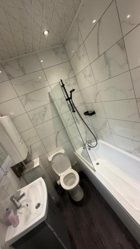 a bathroom with a sink and a toilet and a tub at Central 2 Bed House in Huddersfield
