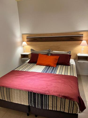 a bedroom with a large bed with two red pillows at Alojamiento Guemes II in San Fernando del Valle de Catamarca