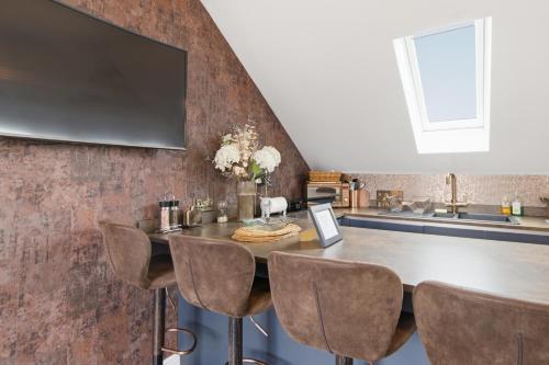 a kitchen with a table with chairs and a tv on a wall at Cannons Loft Central Buxton, Duplex loft 3 bedroom Set over 3 floors stairs no lift sleeps 5 in Buxton