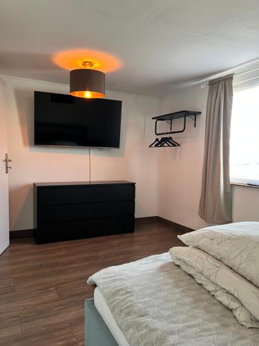 a bedroom with a bed and a flat screen tv at Ferienhaus Luunsche Landpause in Lunow