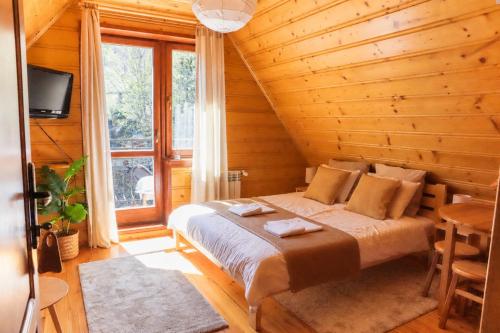 a bedroom with a bed in a wooden house at Tabakowa Chata in Zawoja