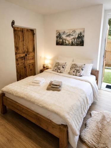 a bedroom with a large bed with white sheets and a window at La Marmotte appartement cosy centre Briancon proche Prorel in Briançon