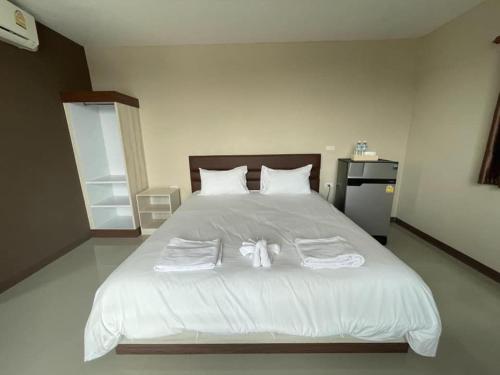 a bedroom with a large white bed with towels on it at ภูมิพิมานเฮ้าส์ in Udon Thani