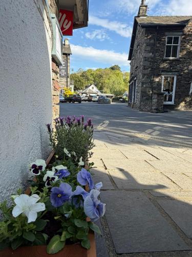 a pot of flowers on the side of a building at Jacksons CafeBar & Guesthouse in Grasmere
