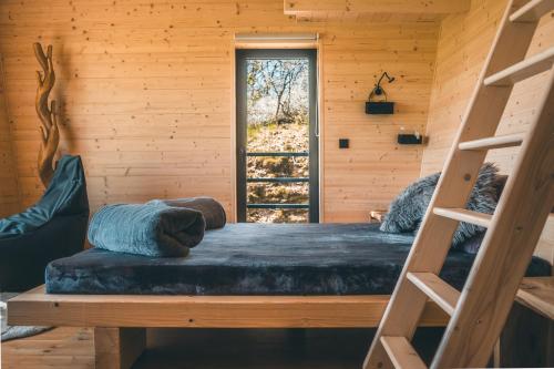 a bedroom with a bunk bed and a window at Rokle Tiny house Plandry in Plandry