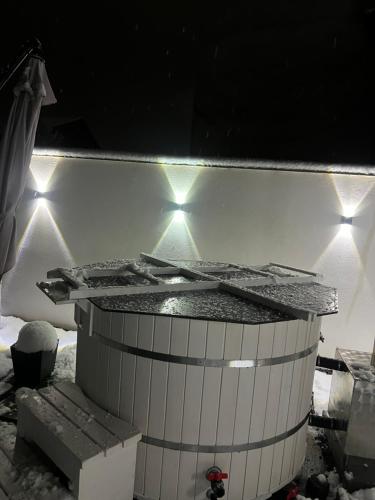 a hot tub in the snow with lights on it at Casa Tofalvi in Sovata
