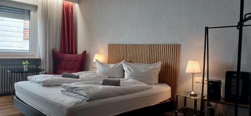 a bedroom with a bed with white sheets and pillows at Hotel Birnbaum in Ansbach