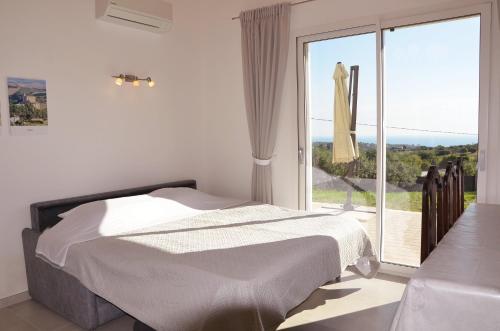 a white bedroom with a bed and a large window at Sea View Villa, 4-6 Guests in Cupra Marittima