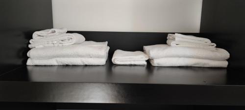 three stacks of towels sitting on a black counter at Diecizero Affittacamere in Barùmini