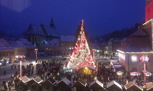 a christmas tree in the middle of a city at night at Apartament Piata Sfatului in Braşov