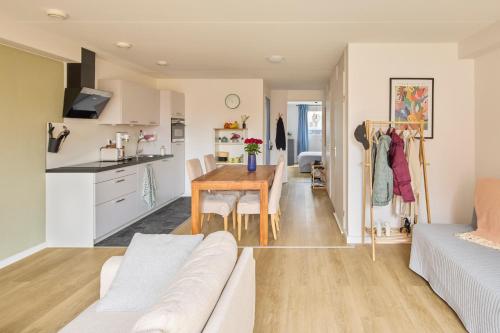 a kitchen and living room with a table and a couch at Nimma Stays Nijmegen in Nijmegen