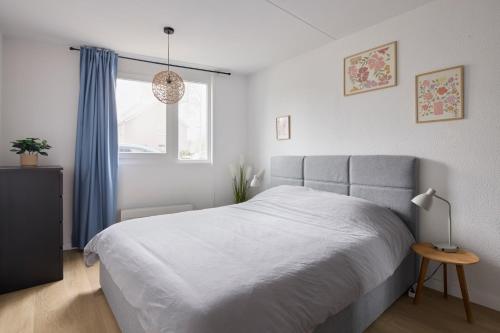 a bedroom with a large bed and a window at Nimma Stays Nijmegen in Nijmegen