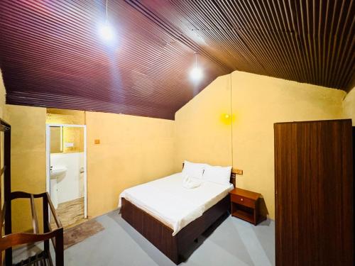 a small room with a bed and a sink at TravelLodge Eco in Arugam Bay