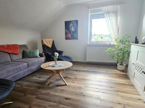 a living room with a couch and a table at Ferienwohnung Schwarzhof- Hahnekräh am Bostalsee, helle 75 qm & hundefreundlich in Nohfelden