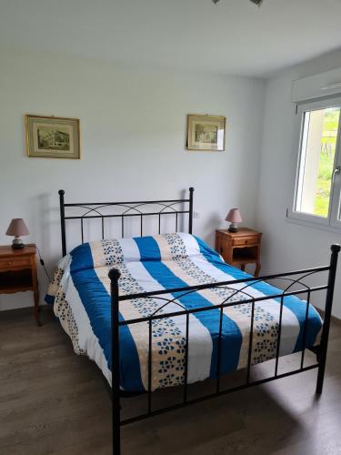 a bedroom with a bed with a blue and white comforter at La Maison de choupette in Fougerolles