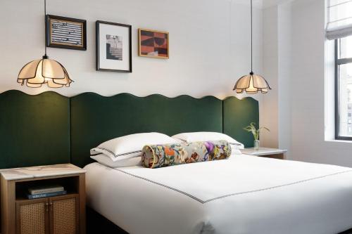 a bedroom with a white bed with a green headboard at Kimpton Hotel Monaco Philadelphia by IHG in Philadelphia