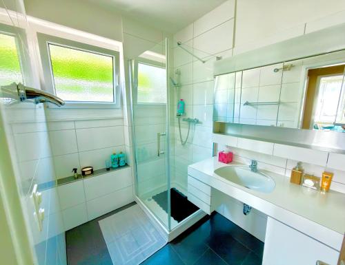 a white bathroom with a sink and a shower at BELVEDERE - Lakeview Apartment 10 min from Lugano in Porza