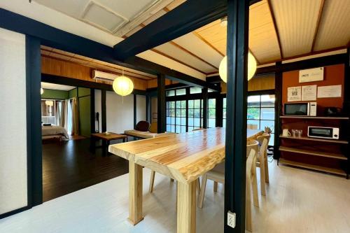 a dining room with a wooden table and chairs at あざみ庵 奄美大島 in Amami