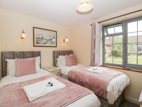 two beds in a room with a window at Oak Tree in Weston-super-Mare