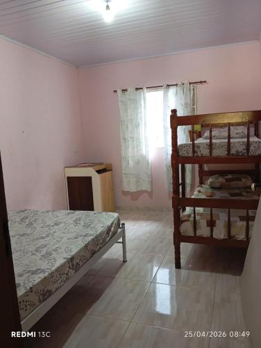 a bedroom with two bunk beds and a window at Sítio Araújo in Ibiúna