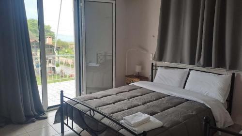 a bedroom with a bed and a large window at Κτήμα Καρνέση 2 in Loutra Edipsou