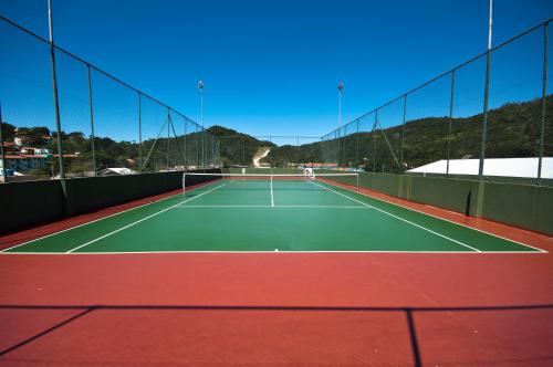 Una pista de tenis con dos personas. en Pousada Vale Del Sol, en Bombinhas