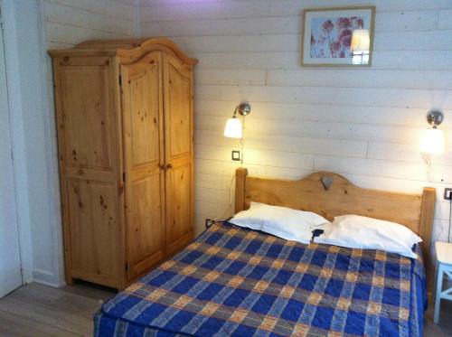 1 dormitorio con 1 cama y armario de madera en Auberge du Lac, en Xonrupt-Longemer