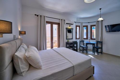 a bedroom with a large bed and a dining room at Sifakis House in Parga