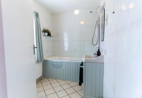 a bathroom with a tub and a sink at Greenway Riverside House - Cahersiveen in Foilmore Bridge