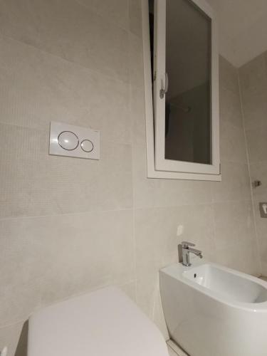 a bathroom with a toilet and a sink and a mirror at Arcadia Hosting Piazza XX Settembre in Bologna