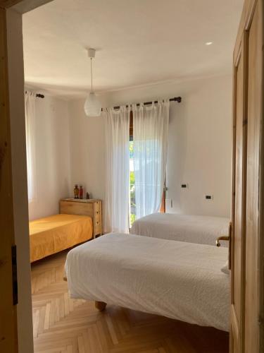 a bedroom with two beds and a window at Casa Martello in Levico Terme