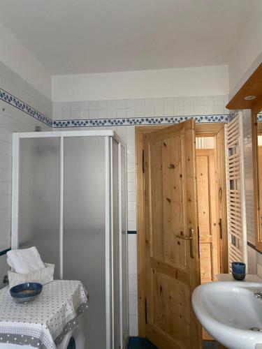 a bathroom with a sink and a shower and a door at Casa Martello in Levico Terme
