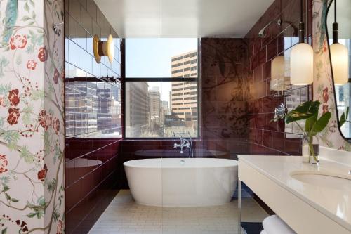 a bathroom with a tub and a sink and a window at Kimpton Hotel Monaco Philadelphia by IHG in Philadelphia