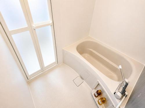 a white bathroom with a tub and a window at 北鎌倉駅徒歩圏 観光便利 最大7名 2寝室 広々滞在 101 in Kamakura
