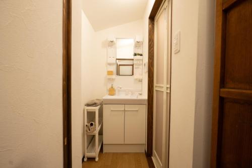 a small bathroom with a sink and a mirror at 離島の宿 Nawanawa Backpackers in Matsuyama