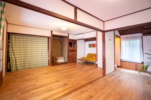 an empty living room with wood flooring at 離島の宿 Nawanawa Backpackers in Matsuyama