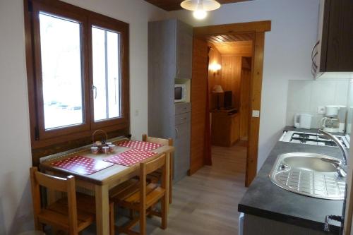 una pequeña cocina con una mesa pequeña y un fregadero en Chalet "les Arcosses", en La Giettaz