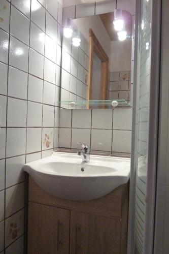 a bathroom with a white sink and a mirror at Chalet "les Arcosses" in La Giettaz