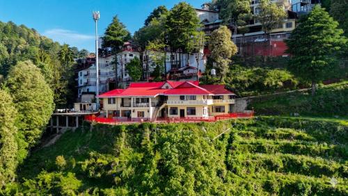a house with a red roof on a hill at Hotel Himdhara, Near Mall Road Dalhousie in Dalhousie
