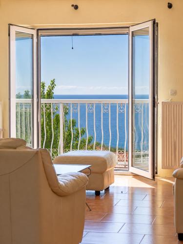 a living room with a view of the ocean at Sunset apartment by the sea in Palaiochórion