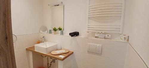 a white bathroom with a sink and a mirror at Hotel Birnbaum in Ansbach
