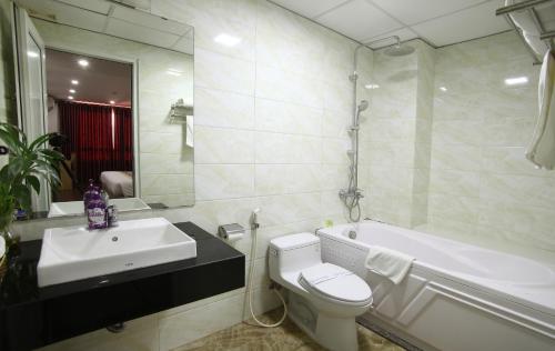 y baño con bañera, aseo y lavamanos. en Blue Pearl Hanoi Hotel, en Hanói