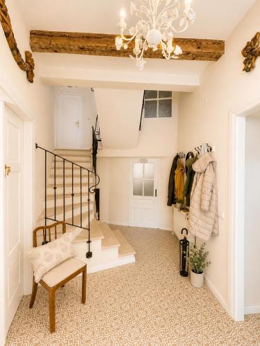 a hallway with a staircase and a chandelier at Cotton House Pool & Garden in Novi Vinodolski