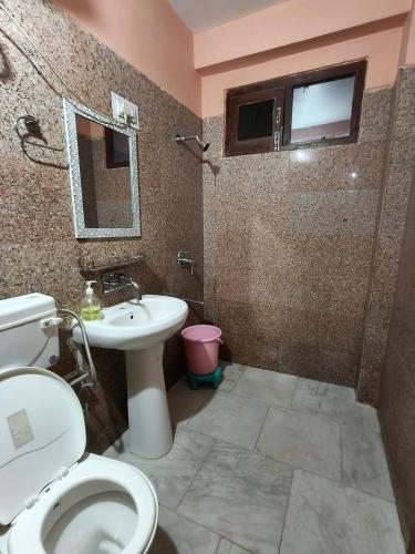 a bathroom with a toilet and a sink at Chander Guest House in Kasol