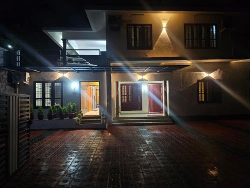 a house with a door at night with lights at Richards Shared Apartment-AC in Thiruvalla